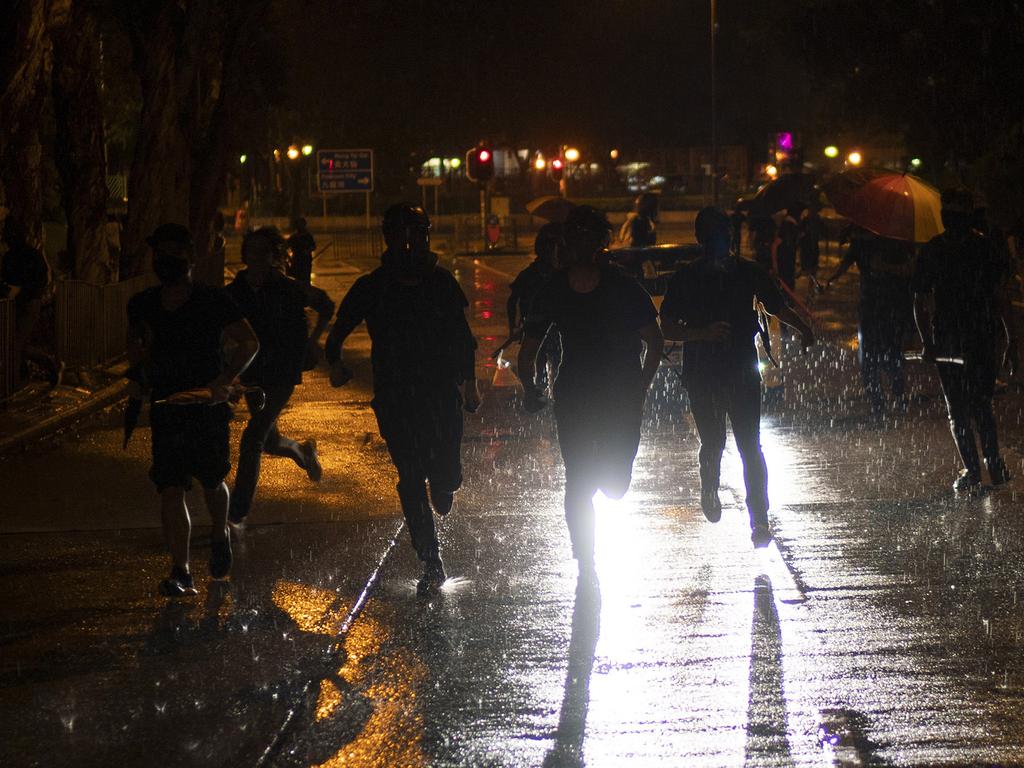 Protesters run away from police in Hong Kong, shouting ‘Wearing a mask is not a crime’. Picture: AP