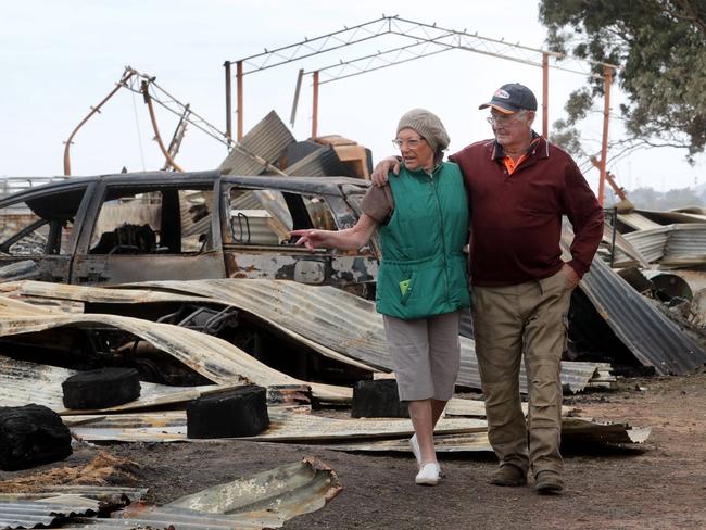 21/03/2018 Ian and Alison Grummett amongst the remains of their woolshed and machinery at their property in Terang. They also lost 70 dairy cows in the fire that burnt most of their property on Saturday night. Picture David Geraghty / The Australian.