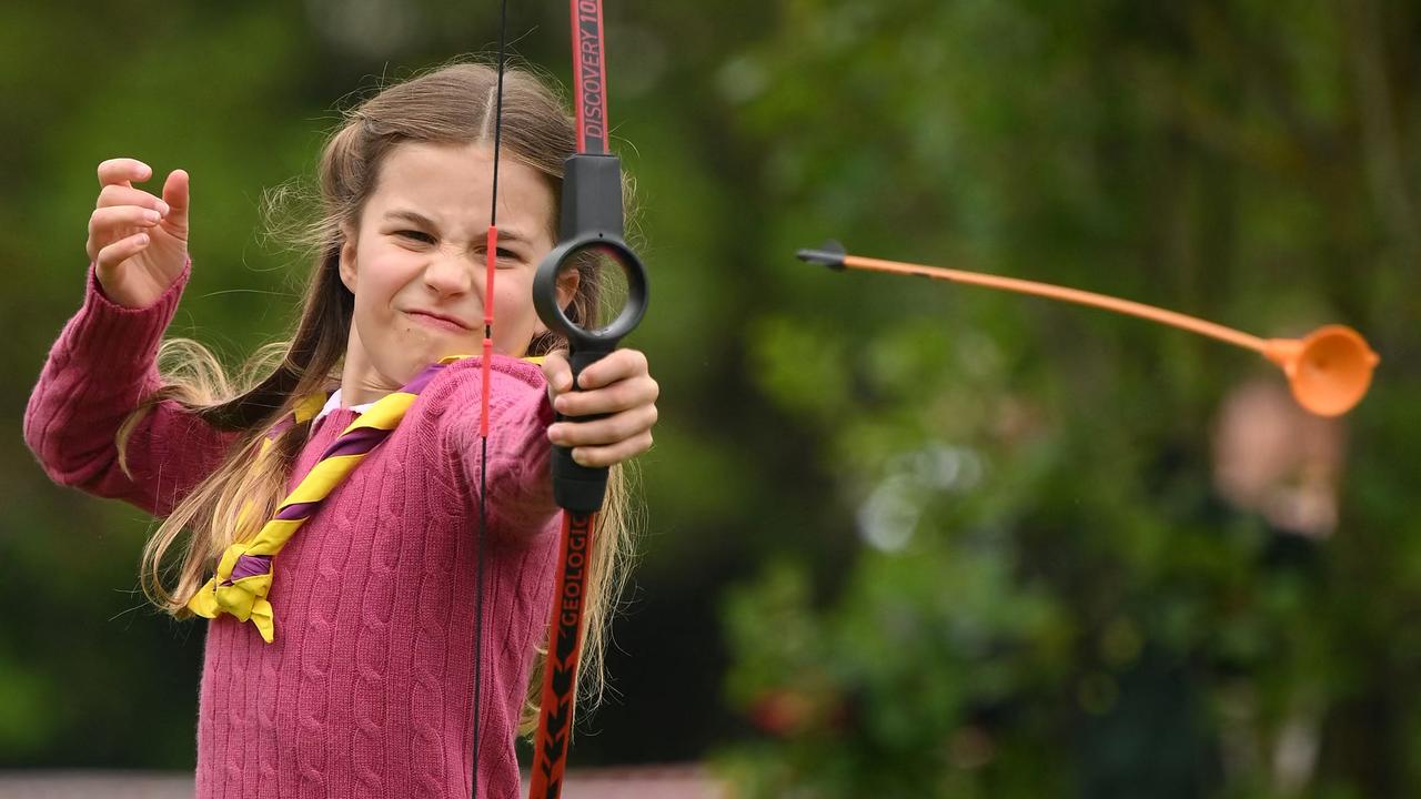 Princess Charlotte of Wales tries her hand at archery. (Photo by Daniel LEAL / POOL / AFP)