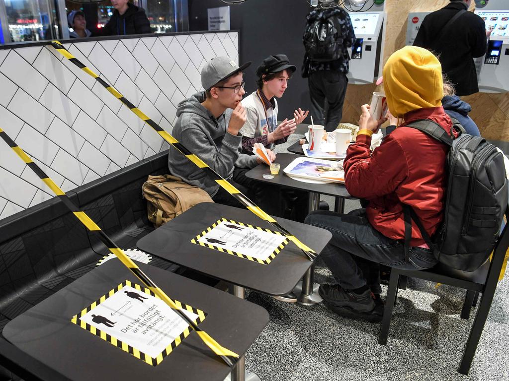 Guests enjoy their meal at a fast food restaurant next to taped off tables in central Stockholm. Picture: Fredrik Sandberg/TT News Agency/AFP