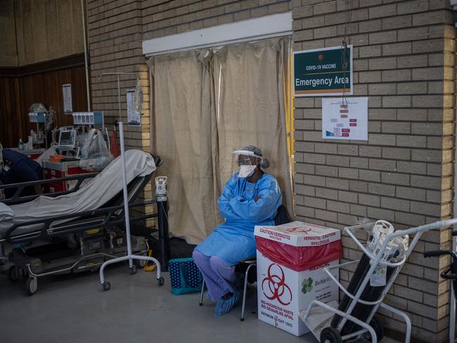 A health care worker looks on as people get vaccinated with Pfizer vaccines at the Bertha Gxowa Hospital in Germiston, South Africa. Picture: AFP