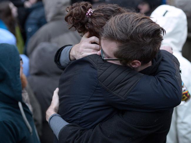 People hug as members of the Squirrel Hill community come together for a student-organized candle vigil in rememberance of those who died earlier in the day during a shooting at the Tree of Life Synagogue in the Squirrel Hill neighborhood of Pittsburgh on October 27, 2018. - The gunman who killed 11 people at a synagogue in Pittsburgh will face federal charges that carry the death penalty, the US Justice Department said. (Photo by Dustin Franz / AFP)