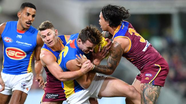 Dayne Zorko and Allen Christensen gang tackle Gold Coast’s Caleb Graham on Saturday night. Picture: AAP