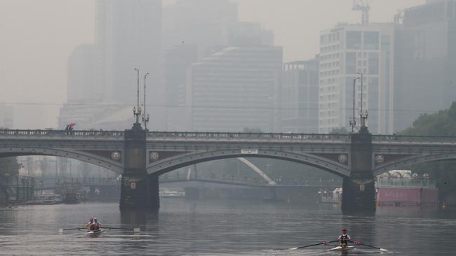 Bushfire smoke haze and light rain hang over the Melbourne CBD on Monday. Picture: David Crosling