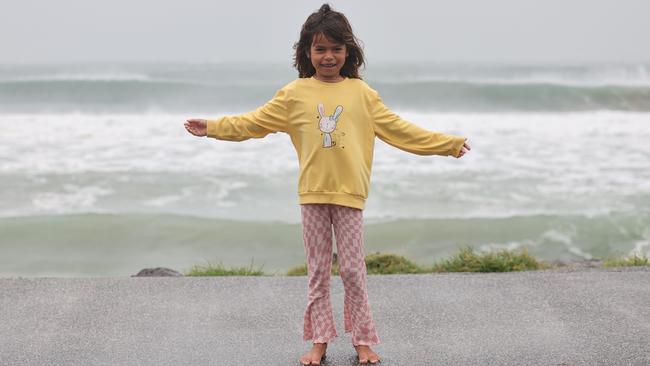 Yasmine Newlands, 7, braves the storm on Friday morning at Main Beach at Byron Bay. Picture: Rohan Kelly