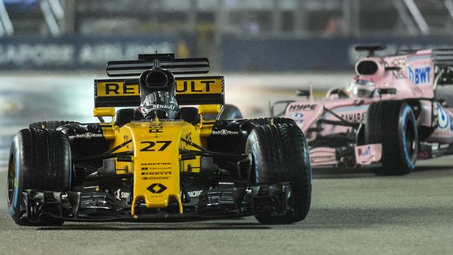 Renault's German driver Nico Hulkenberg (L) and Force India's Mexican driver Sergio Perez (R) drive during the Formula One Singapore Grand Prix in Singapore on September 17, 2017. / AFP PHOTO / MOHD RASFAN