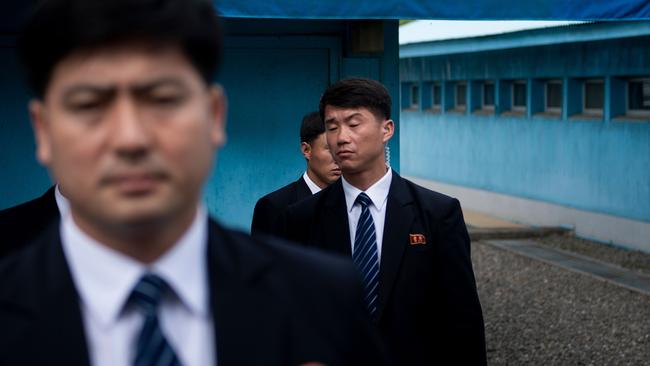North Korean security staff guard a North Korean motorcade while US President Donald Trump and North Korea's leader Kim Jong-un meet in the DMZ. Picture: Brendan Smialowski/AFP