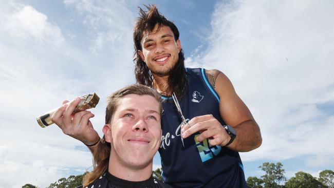 Tino Fa'asuamaleaui gives a haircut - in his own distinct mullet style - to Titans supporter Aidan Mott. Fans can get a free one at the ground before kick off at 6.35pm. Picture: Glenn Hampson