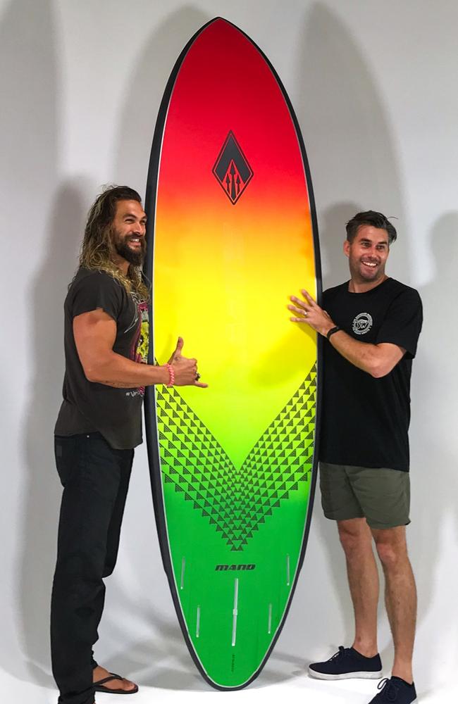 Aquaman and Game Of Thrones star Jason Momoa is wrapped with the custom board he made with The Surfboard Warehouse’s Tim Beban on the Gold Coast. Picture: The Surfboard Warehouse