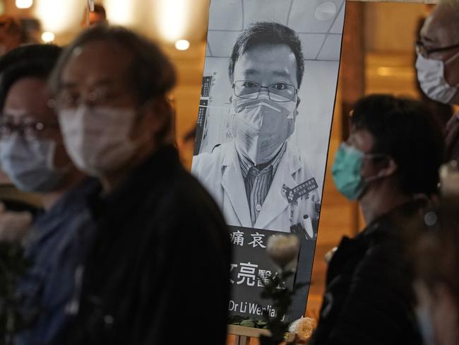 People wearing masks at a vigil for Chinese doctor Li Wenliang, in Hong Kong. The young doctor was reprimanded for warning about China's new virus. Picture: AP Photo/Kin Cheung