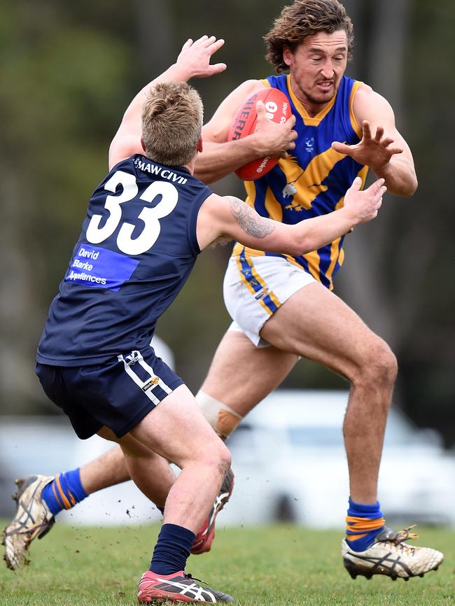 Rampaging Somerville big man Scott Simpson evades a tackle from Rosebud’s Glenn Petersen.