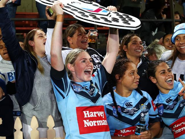 Maddison Studdon of the Blues holds the shield as she celebrates victory