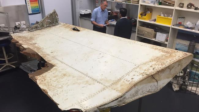 CORRECTION - This undated handout photo released by the Australia Transport Safety Bureau on July 20, 2016 shows Malaysian and Australian investigators in Canberra examining a piece of aircraft debris found on Pemba Island off the coast of Tanzania. Transport ministers from Australia, China and Malaysia will meet July 22, 2016 to discuss the future of the frustrating deep-sea search for missing flight MH370, officials said July 20. / AFP PHOTO / ATSB / Handout / RESTRICTED TO EDITORIAL USE - MANDATORY CREDIT "AFP PHOTO / AUSTRALIA TRANSPORT SAFETY BUREAU" - NO MARKETING NO ADVERTISING CAMPAIGNS - DISTRIBUTED AS A SERVICE TO CLIENTS == NO ARCHIVE / “The erroneous mention[s] appearing in the metadata of this photo by Australia Transport Safety Bureau has been modified in AFP systems in the following manner: adding CANBERRA as location. Please immediately remove the erroneous mention[s] from all your online services and delete it (them) from your servers. If you have been authorized by AFP to distribute it (them) to third parties, please ensure that the same actions are carried out by them. Failure to promptly comply with these instructions will entail liability on your part for any continued or post notification usage. Therefore we thank you very much for all your attention and prompt action. We are sorry for the inconvenience this notification may cause and remain at your disposal for any further information you may require.”