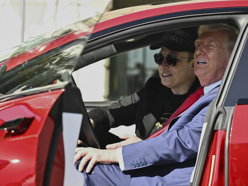 FILE - President Donald Trump and Tesla CEO Elon Musk speak to reporters as they sit in a red Model S Tesla vehicle on the South Lawn of the White House, March 11, 2025, in Washington. (Pool via AP, File)