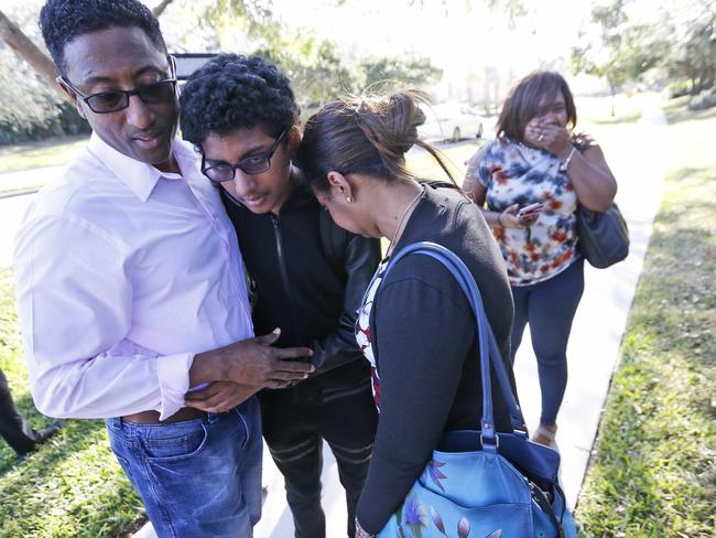 Family members embrace after a student walked out from Marjory Stoneman Douglas High School. Police were warning that the shooter was still at large even as ambulances converged on the scene. Picture: AP Photo/Wilfredo Lee