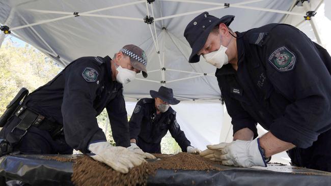 Police pour over items found at the Dawson’s former Gilwinga Drive home.