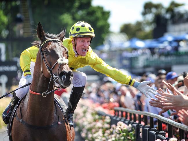 2023 Melbourne Cup Flemington. Running off the Melbourne Cup. Winning jockey Mark Zahra high fives the crowd on race horse Without A Fight on return to scale.     Picture: David Caird