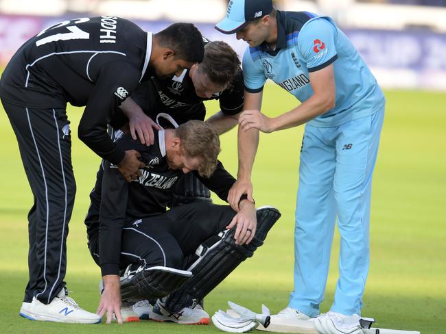 New Zealand batsman Martin Guptill is assisted by teammates and England’s Chris Woakes after the Kiwis’ heartbreaking World Cup loss. Picture: AFP