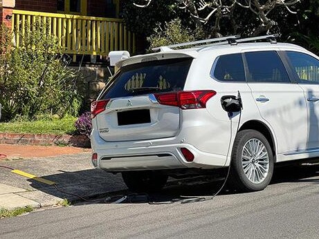 An electric car seen parked in a Manly street, with a power cord snaking from the property onto the road. Picture: 2GB