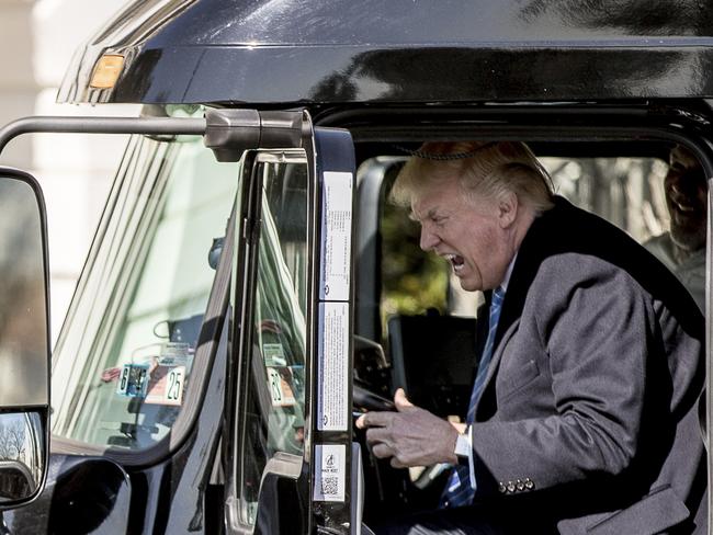 Trump pretends to drive as he gets in an 18-wheeler in March last year. Photo: AP/Andrew Harnik