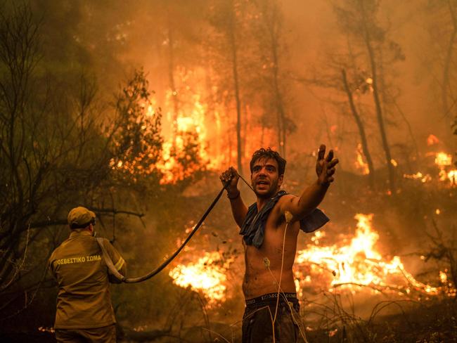 A local resident gestures during an attempt to extinguish forest fires on Evia, Greece's second largest island. Recent fires in Greece, Turkey, Canada and the US have raised concern about our warming planet. Picture: Angelos Tzortzinis/AFP