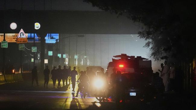 Pakistani police officers remove vehicles and people from the main entry of Nur Khan air base following an Indian missile strike in Rawalpindi, Pakistan, Saturday. Picture: Anjum Naveed/AP