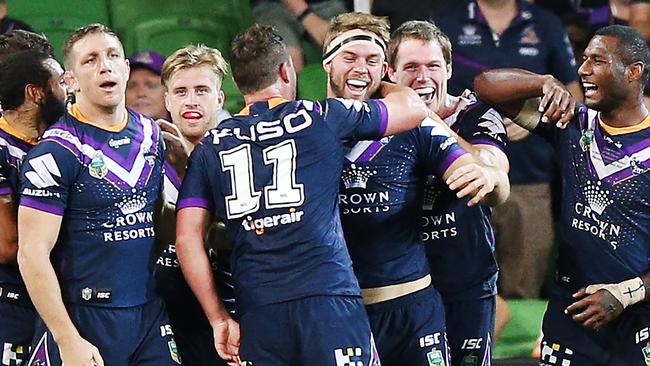 Christian Welch of the Storm celebrates a try with teammates against the Cowboys.