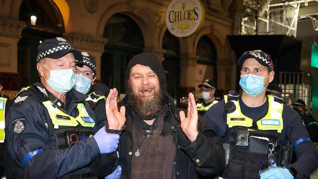 A man is escorted away. Picture : Ian Currie