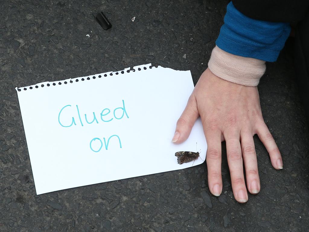 Activists from Extinction Rebellion participate in a protest in Melbourne on Kings Way where some protesters have glued themselves to the road. Picture: David Crosling)/AAP