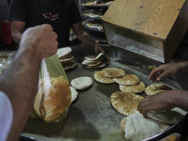 Palestinians bake bread after the World Food Program was able to bring in flour for the first time in over a month as Israel allowed some aid to enter the Gaza Strip, in Deir al-Balah, Gaza Strip, Thursday, May 22, 2025. (AP Photo/Abdel Kareem Hana)
