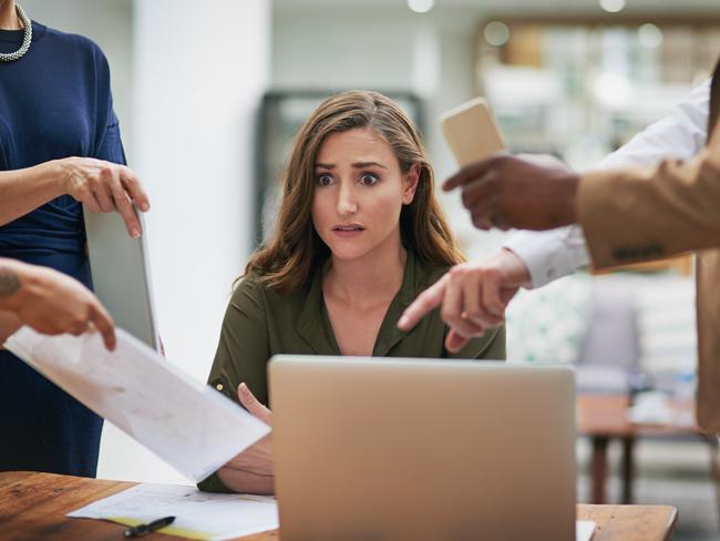 CAREERS: Shot of a young businesswoman looking anxious in a demanding office environment.