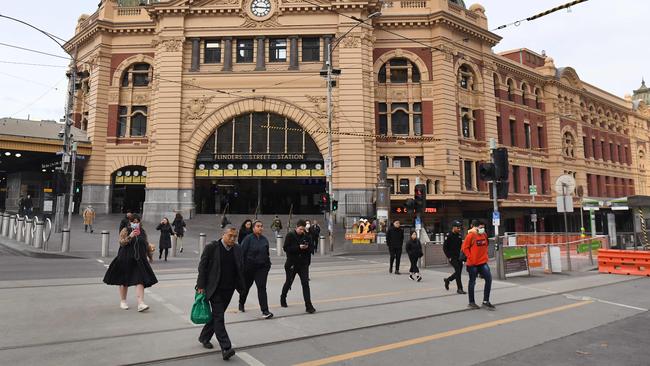 Commuters walk outside the usually bustling Flinders Street station. Picture: William West/AFP.