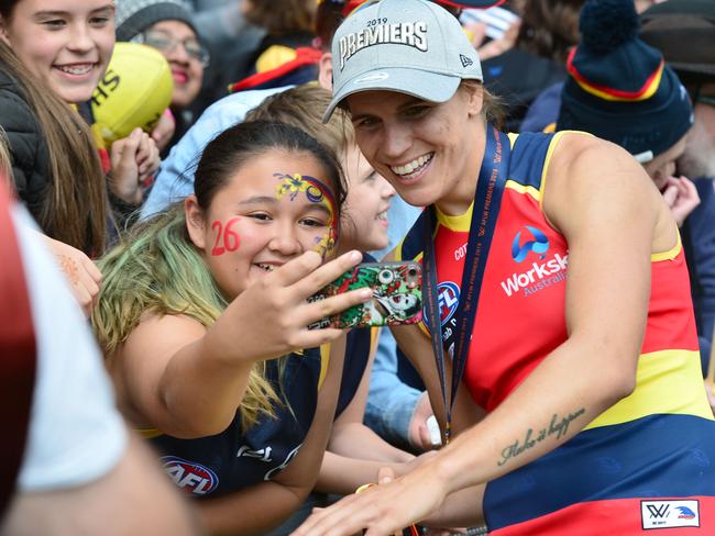 Celebrating her second AFLW premiership with the Crows, Chelsea Randall takes a selfie with a fan who has Randall’s playing No. 26 painted on her face. Picture: AAP/ Keryn Stevens