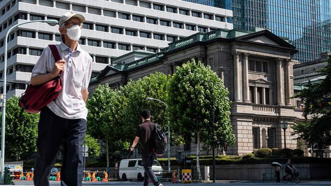 Pedestrians walk past the Bank of Japan building in central Tokyo. Picture: AFP