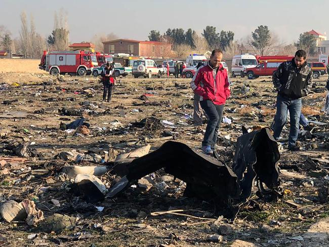 People walk near the wreckage of the doomed plane. Picture: AFP