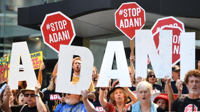 Anti-Adani protesters hold signs outside the company's offices in Brisbane in September 13, 2018. Picture: AAP/Dan Peled