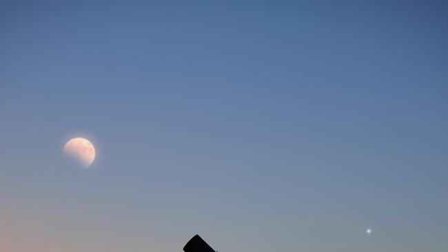 Couple stargazing together with a astronomical telescope, looking at planets, stars, lunar eclipse and meteor shower.