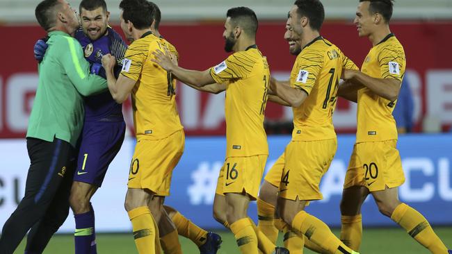Socceroos players celebrate with Mat Ryan after one of his penalty saves