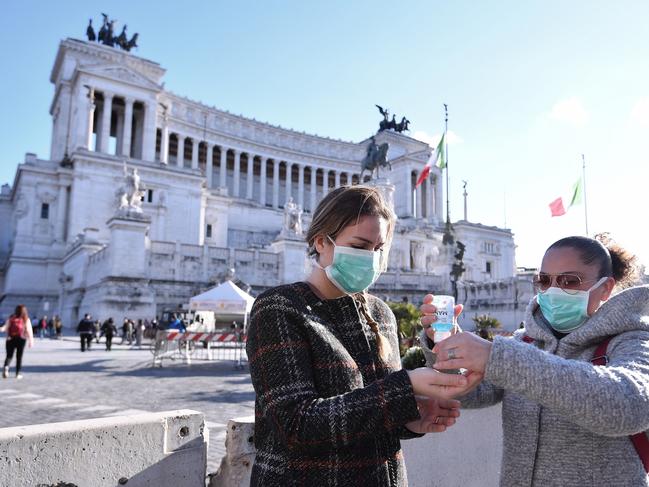 Women disinfect their hands in central Piazza Venezia, in Rome. (Alfredo Falcone/LaPresse via AP)