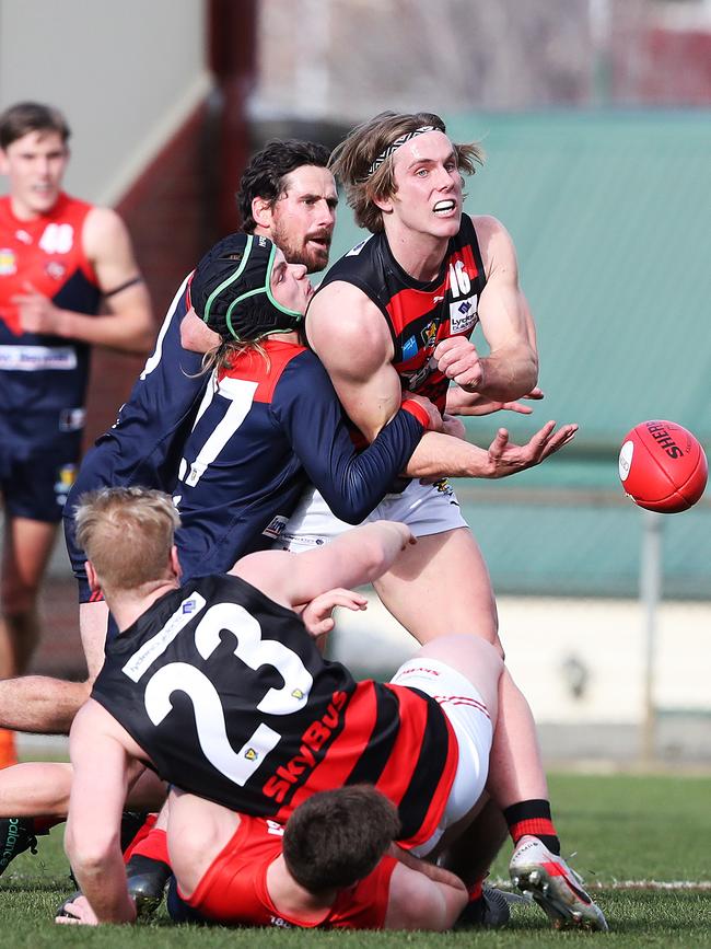 Lauderdale’s Nathan Oakes handballs under a heavy tackle from Angus Norton. Picture: NIKKI DAVIS-JONES