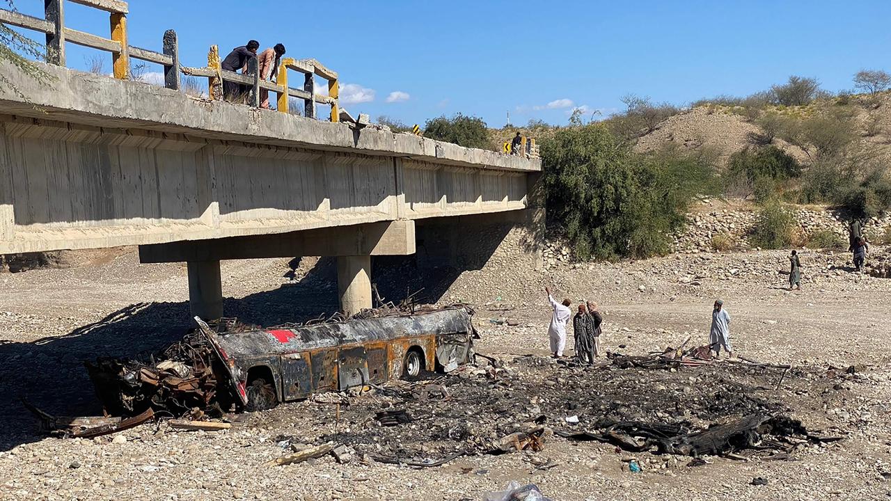 Residents look at the wreckage of a burnt passenger bus at Bela in Lasbela district of Pakistan's Balochistan province on January 29. Picture: Ismail Sasoli/AFP