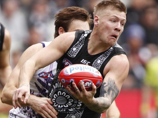 Jordan De Goey of the Magpies handpasses the ball whilst being tackled during the Round 11 AFL match between the Collingwood Magpies and the Fremantle Dockers at the MCG in Melbourne, Saturday, June 1, 2019. (AAP Image/Daniel Pockett) NO ARCHIVING, EDITORIAL USE ONLY