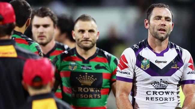Cameron Smith of the Storm walks from the field followed by Robbie Farah of the Rabbitohs.