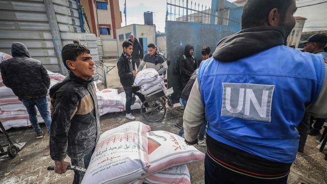 Displaced Palestinians receive food aid at the United Nations Relief and Works Agency for Palestine Refugees centre in Rafah in the southern Gaza Strip. Picture: AFP