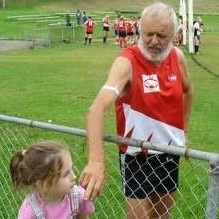 AFL Masters veteran Bill Biok with his number one fan on the sidelines of a match.