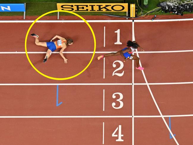 USA's Alexis Holmes runs past Netherlands' Femke Bol who fell before the finish line in the mixed 4x400m relay final during the World Athletics Championships at the National Athletics Centre in Budapest on August 19, 2023. (Photo by Jewel SAMAD / AFP)