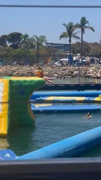 Woman falls off inflatable obstacle course