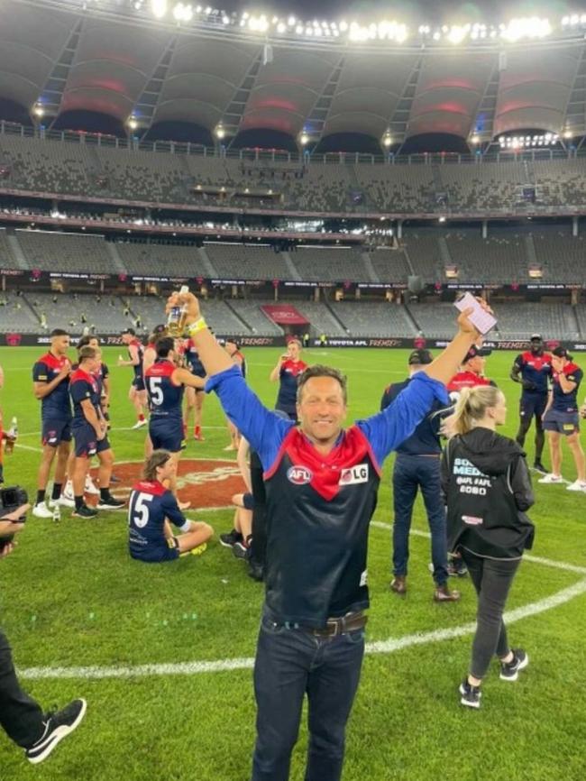 Burbank on the ground at Optus Stadium after the Demons grand final win.