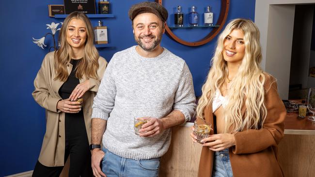 Melbourne DJ Paris Lawrence (right) makes her own gin at Here’s Looking at You Kid distillery with model Tess Shanahan and actor Gyton Grantley. Picture: Mark Stewart