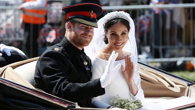 Prince Harry and Meghan wave during their carriage procession in Windsor after their wedding ceremony. Picture: Getty Images.